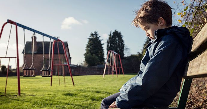 boy sitting alone in playground