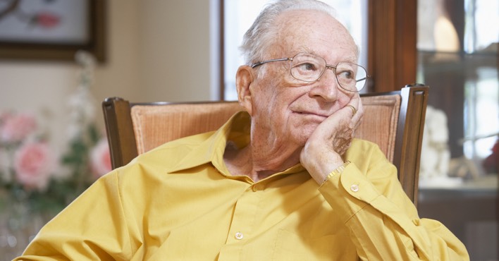 Old man with Alzheimer’s sitting in a chair