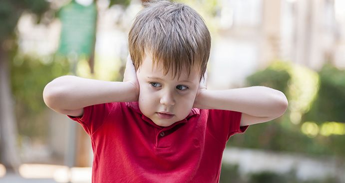 Child with autism covering his ears