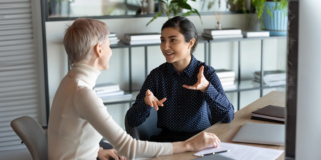 Benefits for children with autism, a discussion between two people in a professional office setting.