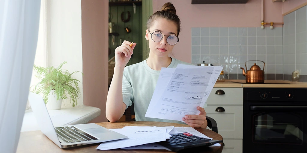 A woman holding documents that pertain to the benefits available to a child with autism.