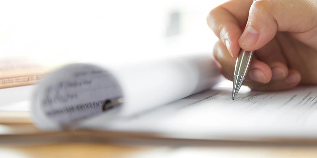 Document being signed as a process of applying for SSI disability benefits.